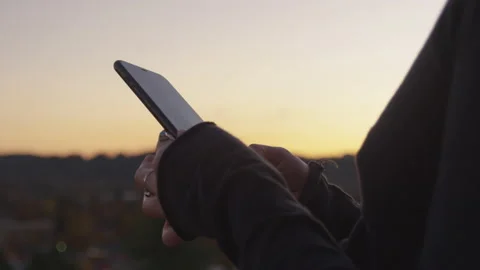 Hands Holding a Cell Phone and Scrolling Stock Footage 208771414