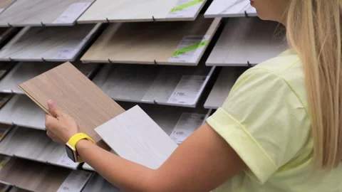 Hands holding ceramic tiles in hardware store comparing options for renovation Video stock 316824766