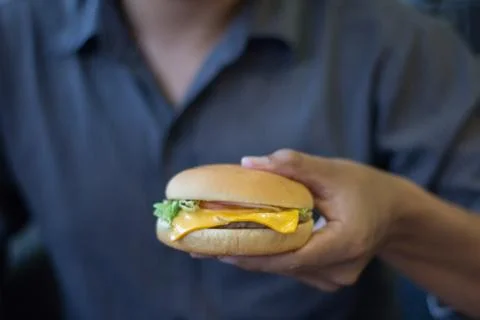 Hands holding a cheeseburger select focus or blurred,Fast food cheeseburger, Stock Photos