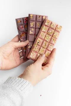 Hands holding chokolate bar of handmade chokolate with nuts and berries Stock Photos