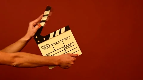 Hands holding clapper board on ruby background Stock Footage 251445441