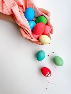 Hands holding colorful painted Easter eggs with one cracked egg on the side Foto stock