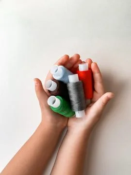 Hands holding colorful thread spools for sewing and crafting creativity Foto stock