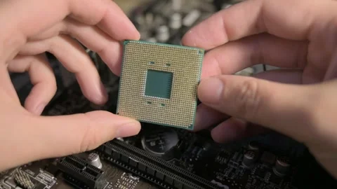 Hands Holding a Computer Processor Above a Motherboard in Close Detail Stock Footage 300671386