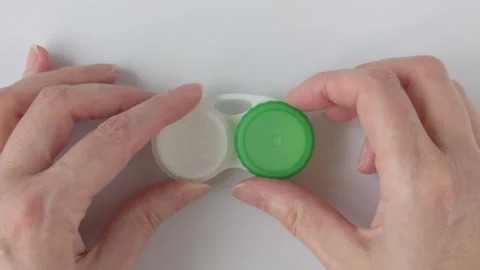 Hands holding contact lenses case white background, closeup Stock Footage 330075813