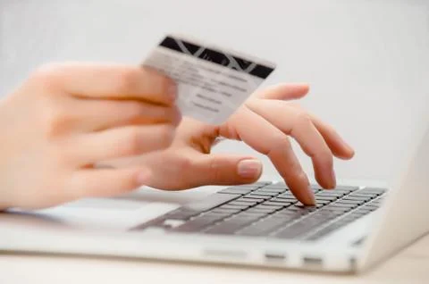 Hands holding credit card and using laptop. Stock Photos