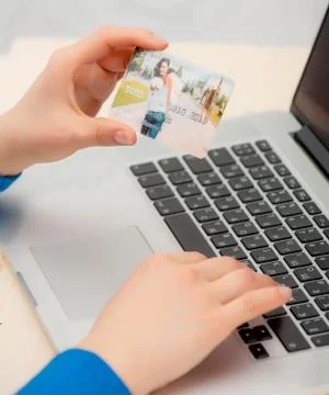 Hands holding credit card and using laptop. Stock Photos