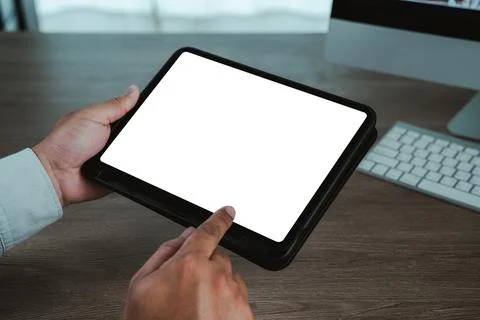 Hands holding a digital tablet with blank white screen on wooden desk, fing.. 스톡 사진