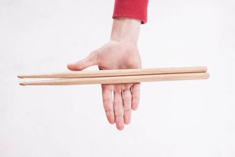 Hands holding drumsticks on a white background Stock Photos