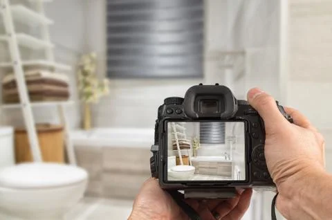 Hands holding DSLR capturing interior of a modern bathroom Stock Photos