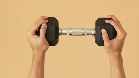 Hands Holding Dumbbell Against Solid Background Видео 311273609