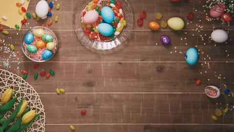 Hands holding easter eggs in front of the table decorated with easter eggs. Top Stock Footage 73945774