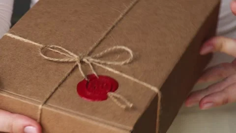 Hands holding eco friendly gift box made of kraft paper tied with twine and Video stock 309310834
