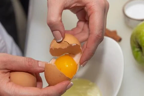 Hands holding egg shell with egg yolk separated Foto stock