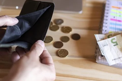 Hands holding empty wallet with few coins Stock Photos