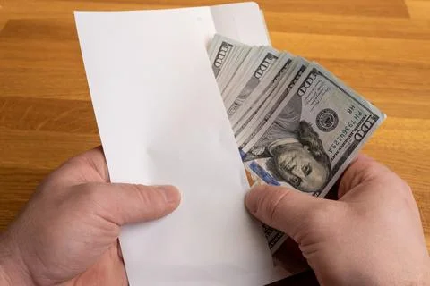 Hands holding envelope with US dollar cash, bribery or illegal payment concept Stock-Fotos