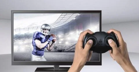 Hands holding gaming controller  with american football player on television Stock Photos
