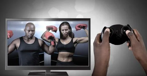 Hands holding gaming controller  with boxing fighters on television Stock Photos
