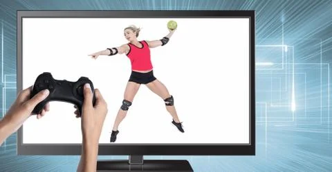 Hands holding gaming controller  with handball volleyball on television Stock Photos