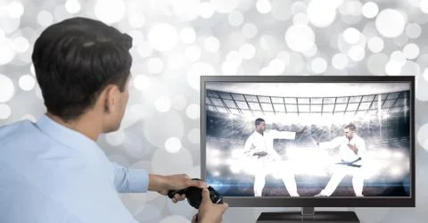 Hands holding gaming controller  with martial arts fighters on television Stock Photos