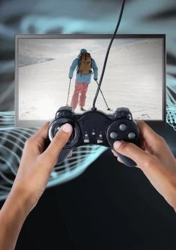 Hands holding gaming controller  with skiing person on television Stock Photos