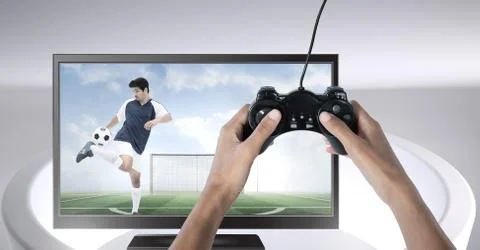 Hands holding gaming controller  with soccer player on television Stock Photos