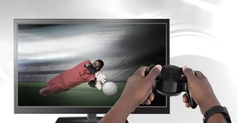 Hands holding gaming controller  with soccer player goalie on television Stock Photos