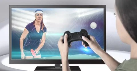 Hands holding gaming controller  with table tennis player on television Stock Photos