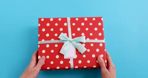 Hands holding gift box turquoise blue background Stock-Footage 182339688