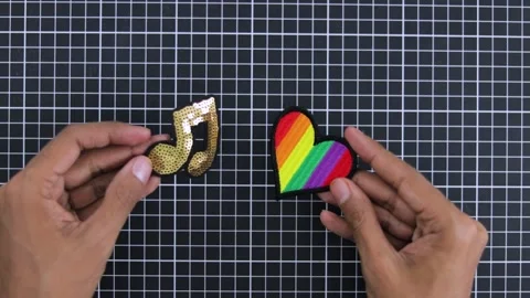 Hands holding glittery music note patch and colorful rainbow heart patch Video stock 280247119