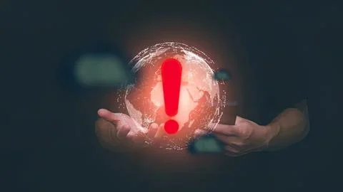 Hands holding a globe with a red exclamation mark warning 스톡 사진