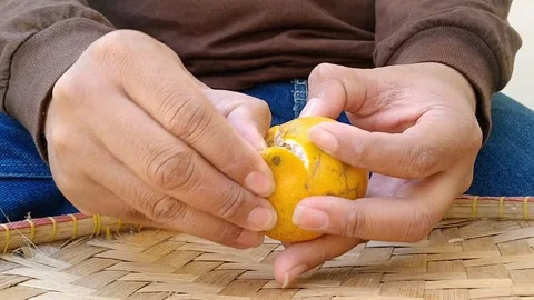 Hands Holding Halved Fresh Oranges on Bamboo Mat Background Stock Footage 340461871