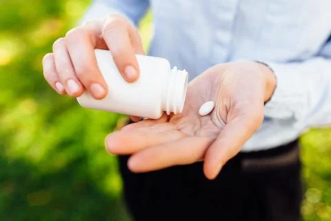 Hands holding a jar with pills, closeup Stock Photos
