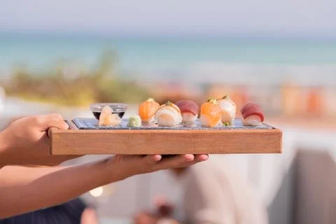 Hands holding a kind of tray with sushi Stock Photos