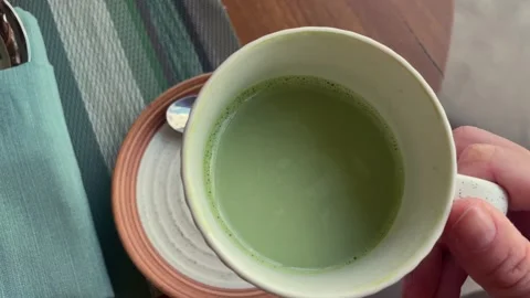 Hands holding a matcha latte at the cafe Stock-Footage 330968742