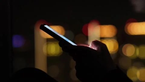 Hands holding mobile phone on the background of night city lights. 動画素材 272621423