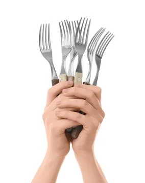 Hands holding multiple silver forks with wooden handles, kitchen utensils for Stock Photos