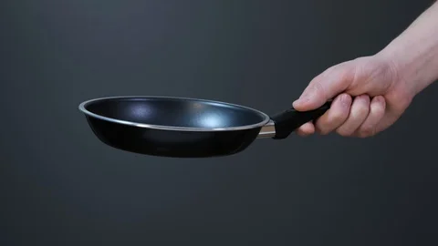 Hands holding new empty black frying pan. Close up. Stock Footage 127786306