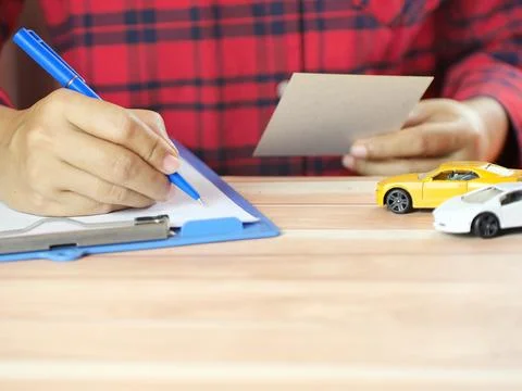 Hands holding notes with car on desk. Car insurance and finance business co.. Stock Photos