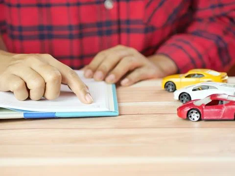 Hands holding notes with car on desk. Car insurance and finance business co.. Foto stock