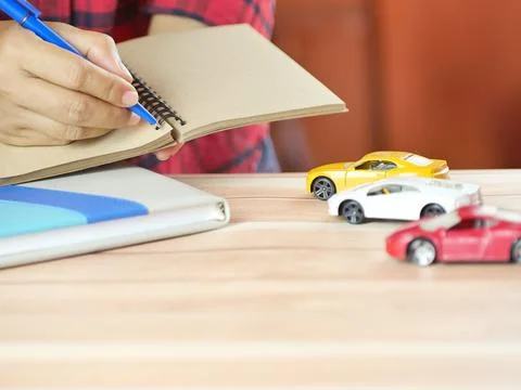 Hands holding notes with car on desk. Car insurance and finance business co.. Stock Photos