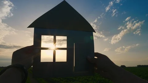 Hands holding a paper model at home in a field at sunset Stock Footage 109042001