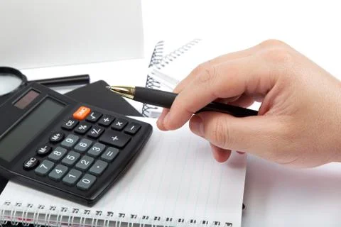 Hands holding the pen over documents and calculator. Stock Photos
