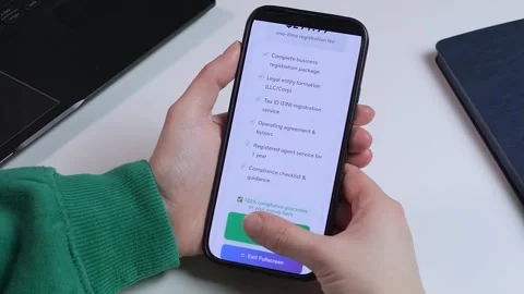Hands holding a phone during a quick LLC registration Video stock 327609643