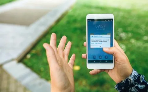 Hands holding phone with update error text on screen Stock-Fotos