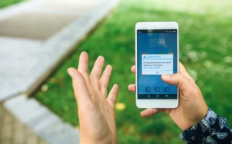 Hands holding phone with update error text on screen Stock Photos