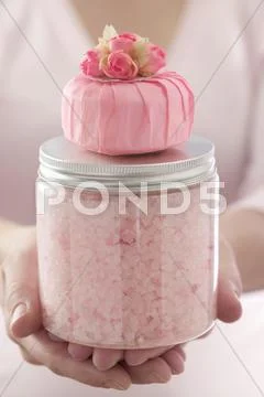 Hands holding pink bath salts and scented soap Stock Photos