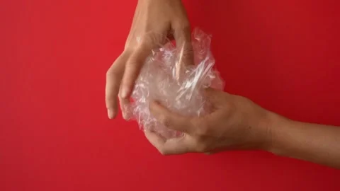 Hands holding plastic waste on the red background Video stock 147370900