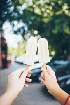 Hands holding popsicles. Stock Photos