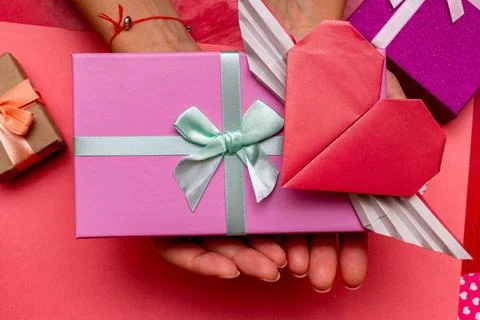 Hands holding present, gift box for Valentine day with heart shape card on th Foto stock